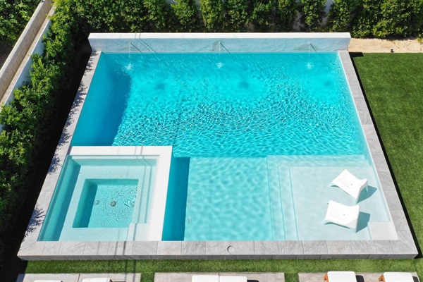 Pool courtyard seen from above with a spa and stone coping